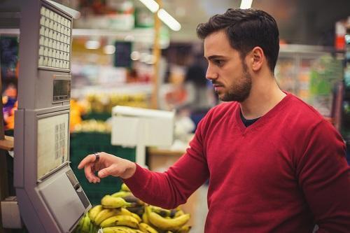 Supermarkten - man weegt fruit in de supermarkt